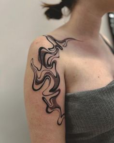 a woman with a black and grey tattoo on her arm