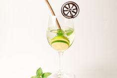 a glass filled with liquid and some green leaves