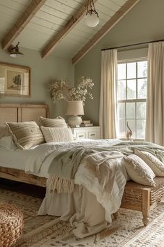 a large bed sitting under a window next to a wooden frame and white pillows on top of a rug