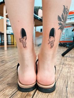 a woman's legs with two tattoos on them