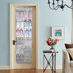 a living room filled with furniture and lots of shoes hanging on the glass door frame