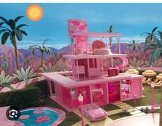 a barbie doll house with pink furniture and palm trees in the back ground, next to a pool