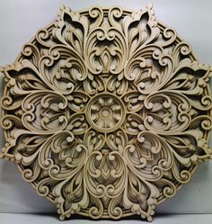 an intricately carved piece of wood on a white surface with no people around it