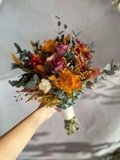 a person holding a bouquet of flowers in their hand