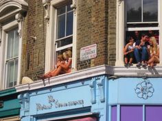 some people are sitting on the ledge of a building