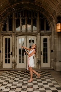 a woman in white dress holding a tennis racquet on checkered tile floor