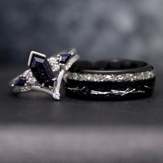 two wedding bands with blue and white diamonds on them, one is black and the other is white gold