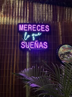 a neon sign that says mereces de que suenas on the side of a building