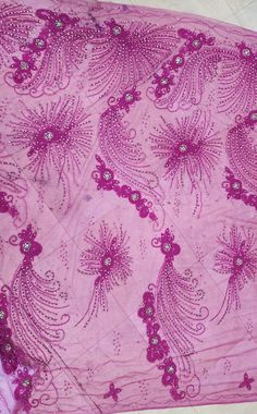 an image of a pink cloth with flowers and butterflies on the fabric, as well as beads or sequins