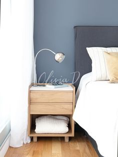 a bedroom with a bed, nightstand and white sheets on the floor in front of a window