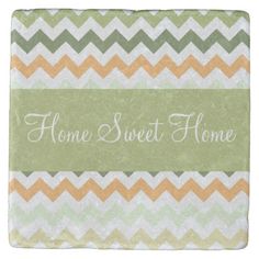 a green and yellow chevroned tile with the words home sweet home on it