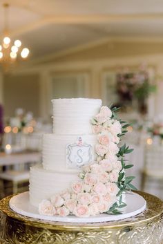 a white wedding cake with pink flowers on the side and a clock at the top