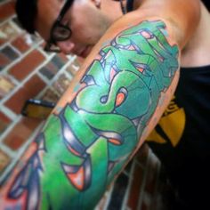 a man with a green tattoo on his arm