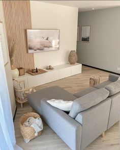 a living room filled with furniture and a flat screen tv sitting on top of a wooden floor