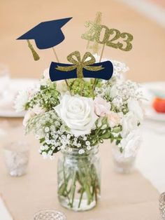 a vase filled with flowers sitting on top of a table next to glasses and plates