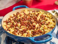 a blue pot filled with macaroni and cheese sitting on top of a table