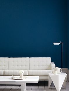 a living room with blue walls and white furniture