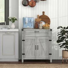 a kitchen with white walls and wooden cabinets, potted plants on the counter top