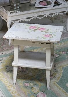 an old white table with pink flowers on it