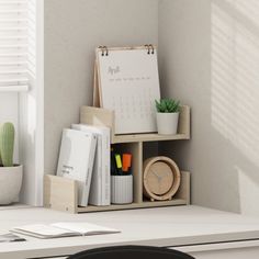 a desk with a clock, cactus and other office supplies