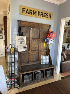 a wooden bench sitting in the middle of a living room next to a sign that says farm fresh