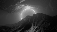 an artistic view of mountains and the sun shining through it's center, in black and white