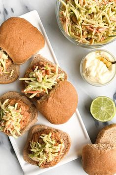 some food is on a white plate and next to a bowl of coleslaw