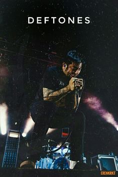 a man sitting on top of a stage next to a microphone