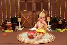 a baby is sitting on the floor in front of decorations