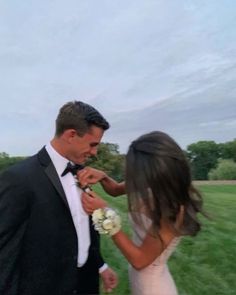 a bride and groom are standing in the grass