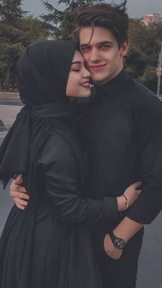 two people standing next to each other hugging