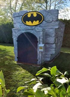 an outdoor play house with a batman sign on it