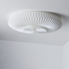 a white ceiling light hanging from the ceiling in a room with no one around it