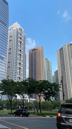 cars are driving down the street in front of tall buildings