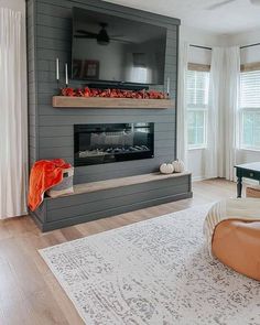 a living room filled with furniture and a flat screen tv mounted on the wall above a fire place