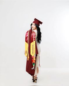 a woman in a graduation gown and cap is standing with her hands on her hips