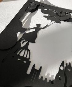 the silhouettes of two people are shown in this paper cut art piece, which is black and white