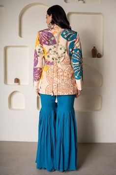 Multi-colored crepe blazer with floral print and cutdana hand embroidery. Comes with blue georgette sharara and a belt with hangings. - Aza Fashions Bohemian Sharara With Cutdana For Reception, Multicolor Sharara With Cutdana Straight Kurta, Bohemian Sharara With Gota Work For Reception, Multicolor Chanderi Sharara For Reception, Bohemian Long Sleeve Sharara With Pallu, Bohemian Sharara For Diwali Reception, Multicolor Semi-stitched Kurta For Reception, Multicolor Long Sleeve Traditional Wear With Gota Work, Multicolor Chikankari Embroidery Sets For Reception