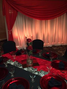 the table is set with black and red place settings