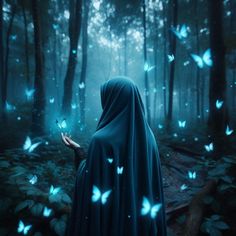 a woman in a blue cloak holding a lit candle with butterflies flying over her head