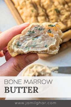 a hand holding a cracker with some food on it and the words bone marrow butter