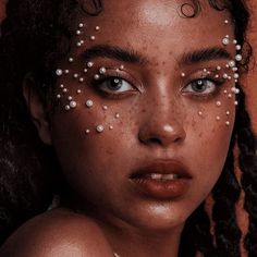 a close up of a woman with freckles on her face and eyeliner