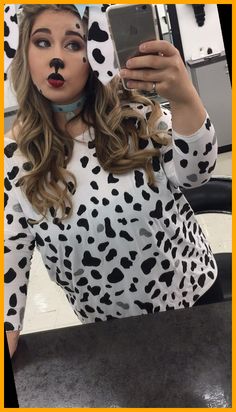 a woman taking a selfie with her cell phone wearing a dalmatian costume