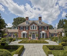 a large red brick house surrounded by hedges