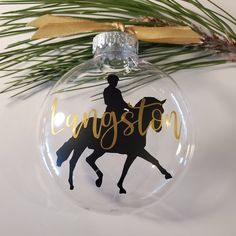 a glass ornament with a horse and rider on it that says langston