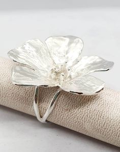 **FREE EXPRESS SHIPPING** This silver ring encapsulates the timeless elegance of nature with a striking buttercup flower as its centerpiece Crafted with meticulous attention to detail, the buttercup is sculpted in exquisite detail, capturing the delicate petals and intricate curves that define this beloved bloom. Set upon a delicate band, the ring is formed by two slender rods that gracefully intertwine and meld into one, symbolizing unity and strength The silver of the band is polished to a rad Flower Silver Ring, Centerpiece Craft, Buttercup Flower, Silver Flower Ring, Ring Flower, Nature Ring, Handmade Flower, Ring Boho, Ring Women