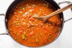 a pot full of soup with a wooden spoon in it