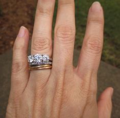 a woman's hand with a ring on it and a diamond in the middle