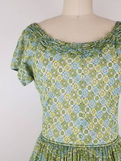 "Lovely green fit and flare dress from the late 40s I think (from the zipper). It has cute gathering around the neck line. Skirt is fully gathered at waist. Dress goes over the head and closes with a 11 inch 'Talon' brand green metal zipper on the side. The bodice is fully lined, but the skirt is not and the fabric is semi sheer so it may require a petticoat underneath (last photo I tried to show my hand thru the fabric. Photographed with white crinoline underneath). Nice construction of the arm Green Retro Vintage Dress With Short Sleeves, Green Retro Vintage Dress, 1950s Green Short-sleeved Dress, 1950s Style Green Vintage Dress For Spring, 1950s Green Short Sleeve Dress, 1950s Style Green Lined Dress, 1950s Style Green Short Sleeve Dress, Green Vintage Style Dress For Summer, Green Vintage Dress For Summer