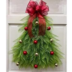 a christmas wreath hanging on a door with red and green decorations around the wreaths